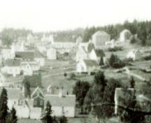 Image de l'école Seal Cove suite à l'ajout de 1935. La date indique 'post-WWII' (après la Seconde Guerre mondiale). L'école est le long bâtiment blanc dans la partie supérieure, au centre de l'image.; Grand Manan Archives