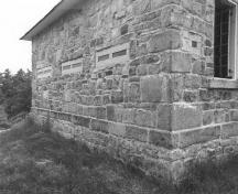 Corner view of the Jones Falls Defensible Lockmaster's House, showing the exterior walls, constructed of rough-faced masonry blocks, 1989.; Parks Canada Agency / Agence Parcs Canada, 1989.