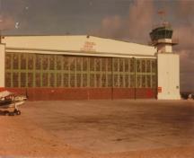 Vue de la façade ouest de l'aérogare de Churchill, qui montre les six grands panneaux des portes de hangar vitrées.; Transport Canada / Transports Canada