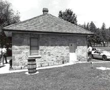 Rear view of the Defensible Lockmaster's House, showing the exterior thick limestone walls, constructed of rough-faced masonry blocks, 1989.; Parks Canada Agency / Agence Parks Canada, Couture, 1989.
