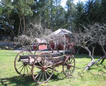 1589 Millstream Road, Caleb Pike Heritage Park, view from Millstream Road to Old Schoolhouse showing wagon and fruit trees; Ditrict of Highlands, 2000