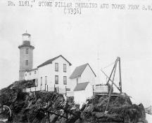 Photographie historique du phare du Pilier-de-Pierre montrant les bâtiments connexes qui ont entouré la tour; Bibliothèque et Archives Canada | Library and Archives Canada, PA-164478