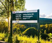 Vue de la colline Battle Hill des Gitwangaks et son enseigne; Parks Canada | Parcs Canada