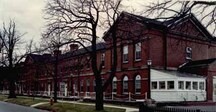 Vue en angle de la maison Wellington, montrant la façade sud et les murs extérieurs construits de brique rouge.; Parks Canada | Parcs Canada, Canadian Forces, NS-85-6-5687