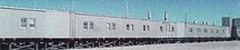 Façade latérale du Train modulaire A, montrant le revêtement extérieur en métal et la taille, la forme et la disposition des portes et des fenêtres, qui sont régies par la fonction de chaque module, 1998.; (Canada, North Warning System Office / Bureau du système d'alerte du Nord , 1998.)