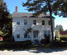 This view of the two storey front façade includes five window or door openings per storey illustrating the neo-classic style.; PNB 2004